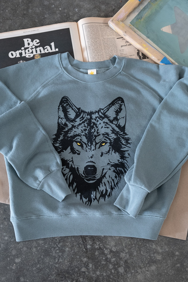 the "mother wolf" vintage wash sweatshirt on green